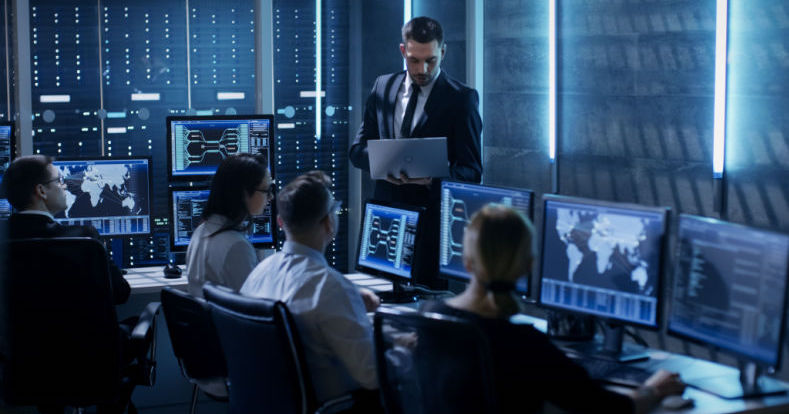 Profissionais de TI trabalham no Centro de Controle de Sistema