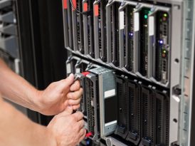 Zwei menschliche Hände an einem Serverturm eines Rechenzentrums