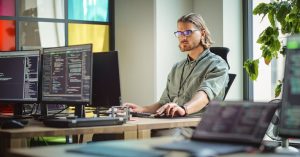 Male Data Scientist Coding on Desktop Computer