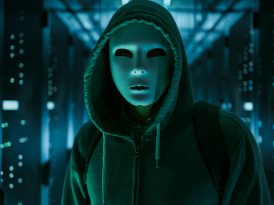 Masked Hacker in a Hoodie Standing in Corporate Data Center