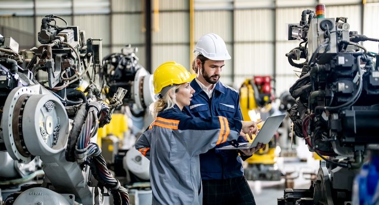 Engineer with robot in automotive parts factory