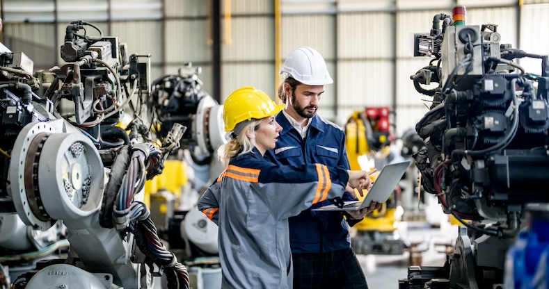 Engineer with robot in automotive parts factory