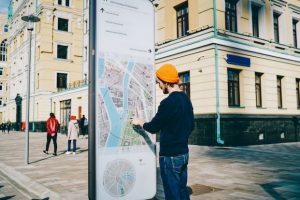 Young male traveler using modern smart board with map and useful information for tourists