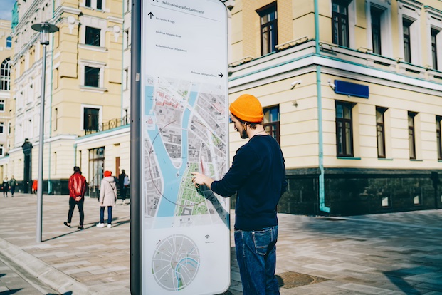 Young male traveler using modern smart board with map and useful information for tourists