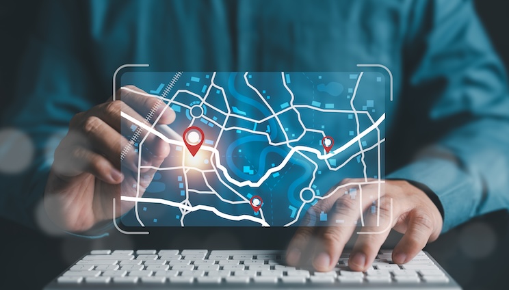 Businessman marking location pin points and search addresses on geolocation map application.